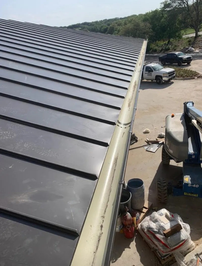 Standing seam panel and gutter detail on a metal roofing jobsite in Cairo